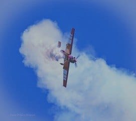 A single aerobatic plane turns inside a cloud of smoke. — by Ed Shpritz