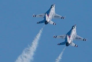 Two jets climb together against a clear blue sky. — by Ed Shpritz