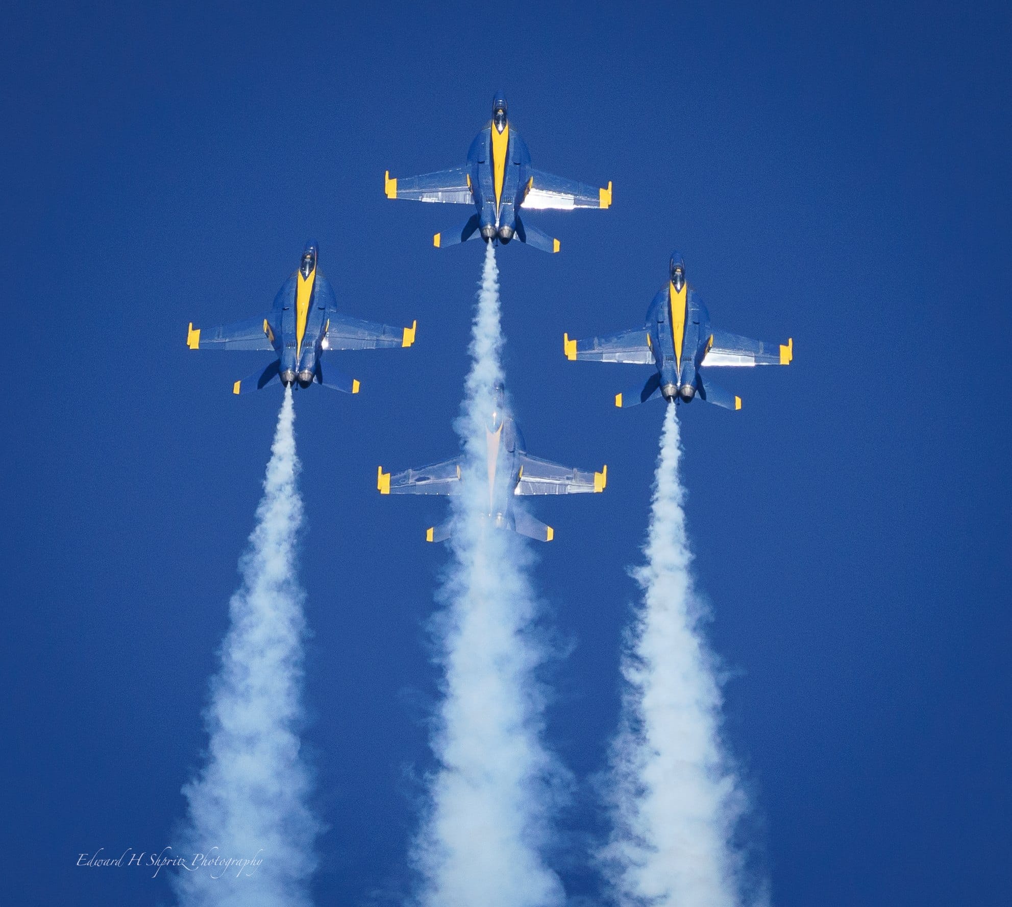Five jets rise in a balanced formation with white smoke. — by Ed Shpritz