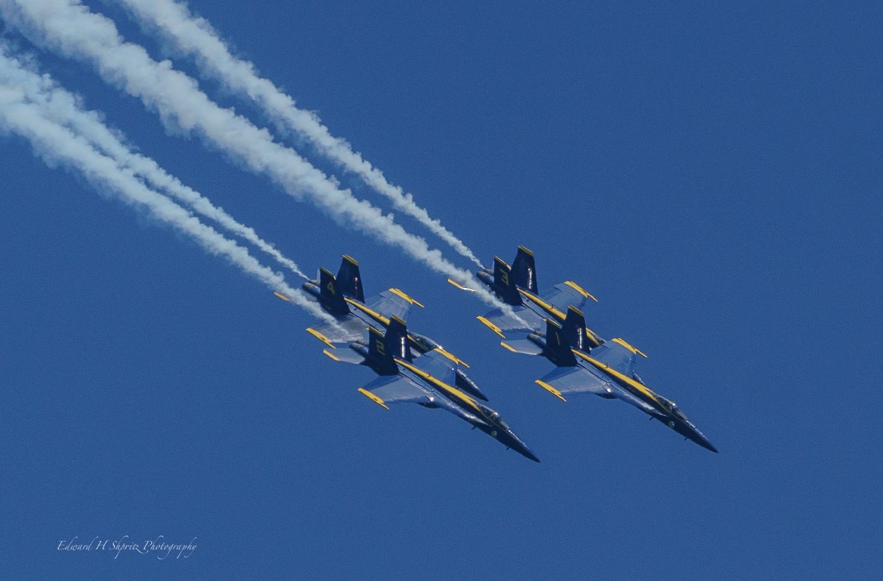 Four Blue Angels jets fly in a tight diamond formation. — by Ed Shpritz