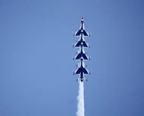 A tight line of jets climbs vertically through the sky. — by Ed Shpritz