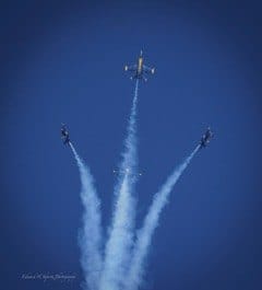 Three jets rise in a V-shaped formation with smoke trails. — by Ed Shpritz