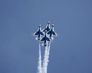 Four jets rise together with white smoke trailing behind. — by Ed Shpritz