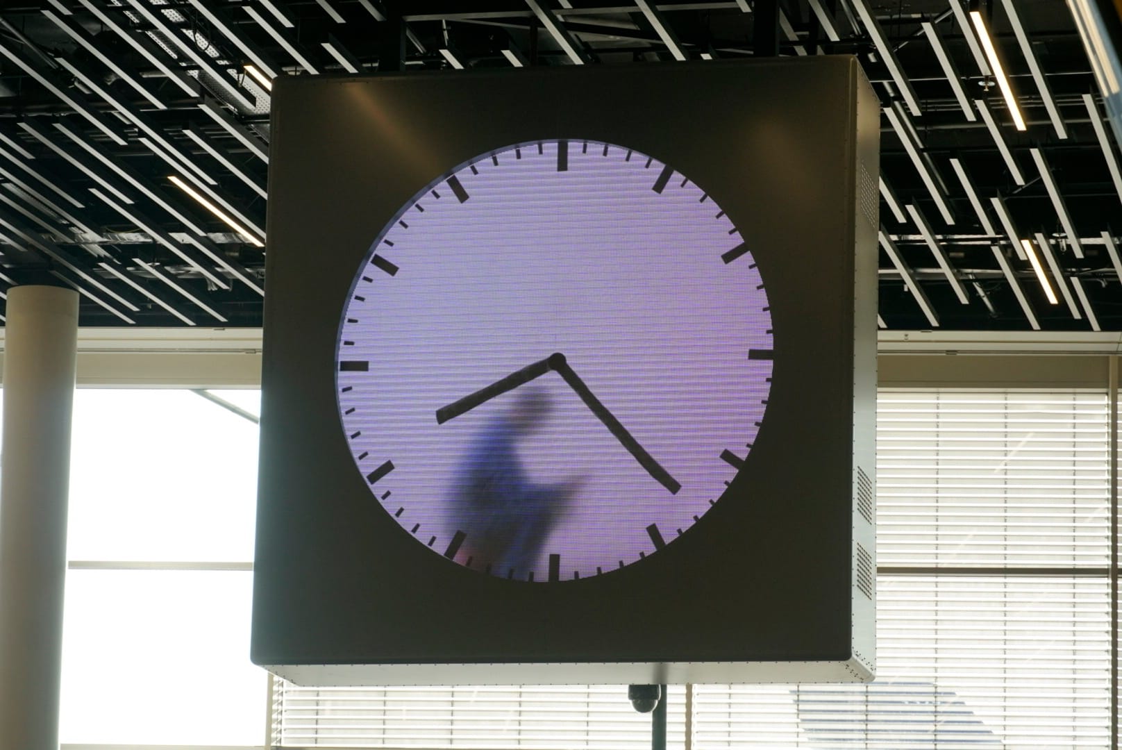 Figure passing behind a monumental clock face