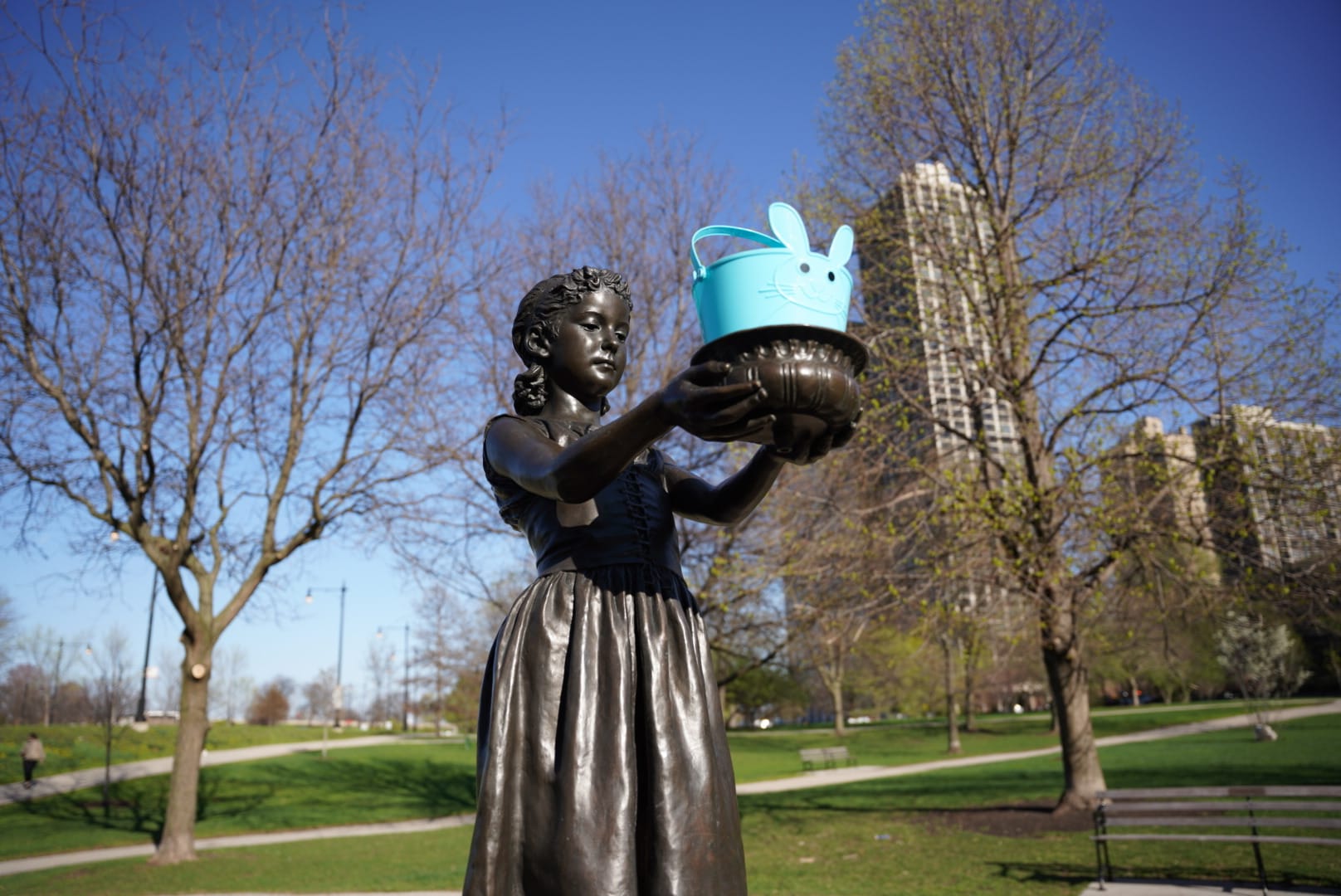 Decorated bronze girl holding a blue rabbit basket