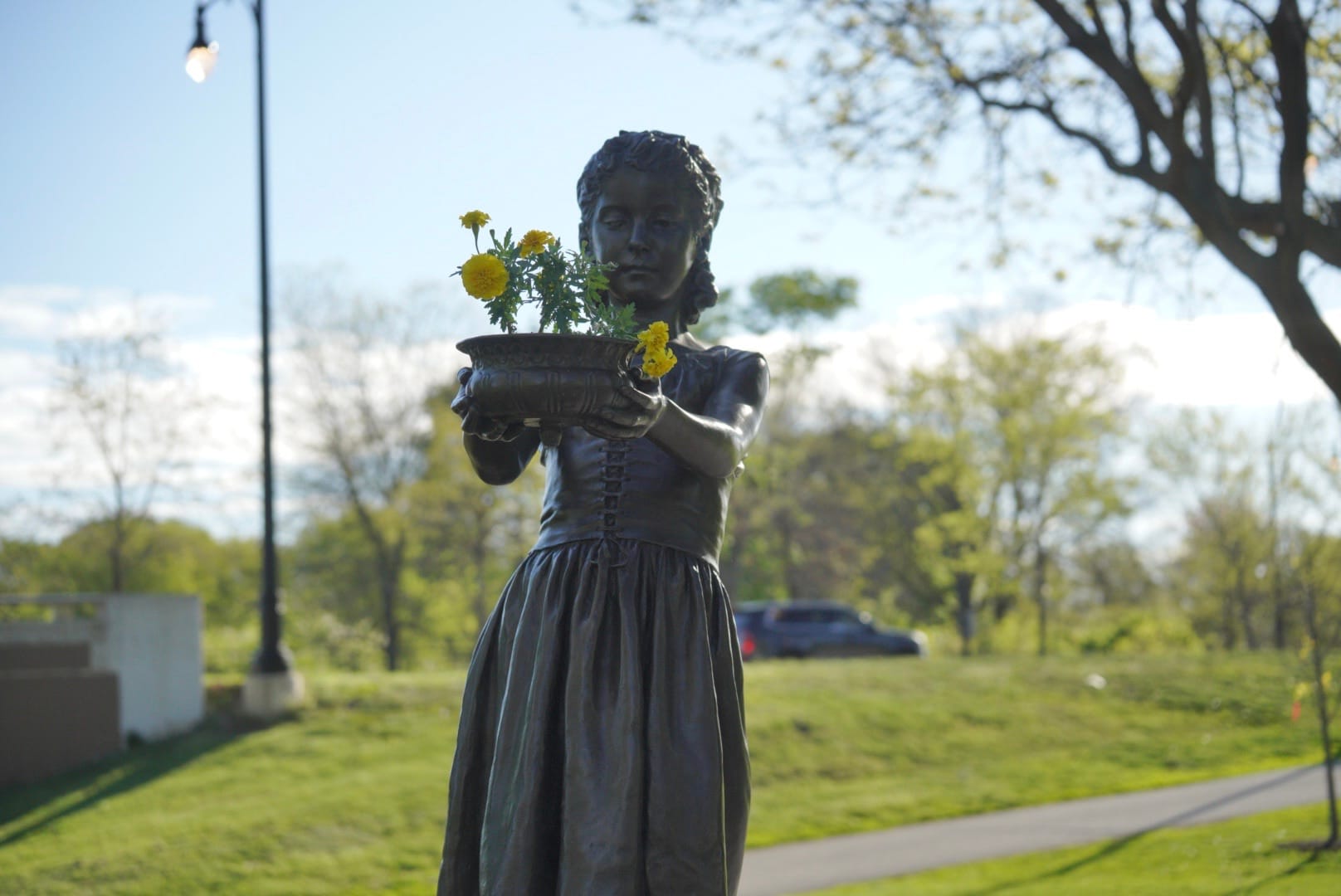 Decorated bronze girl holding yellow flowers