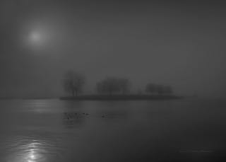 Moonlight reflected across a fog-covered lake