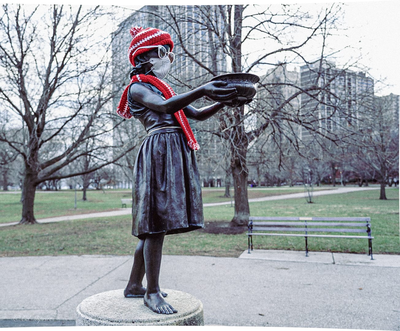 Decorated bronze girl wearing a mask and red knitwear