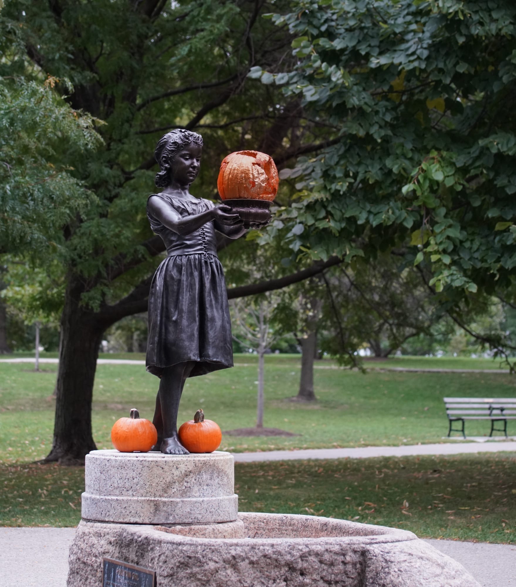 Decorated bronze girl surrounded by pumpkins