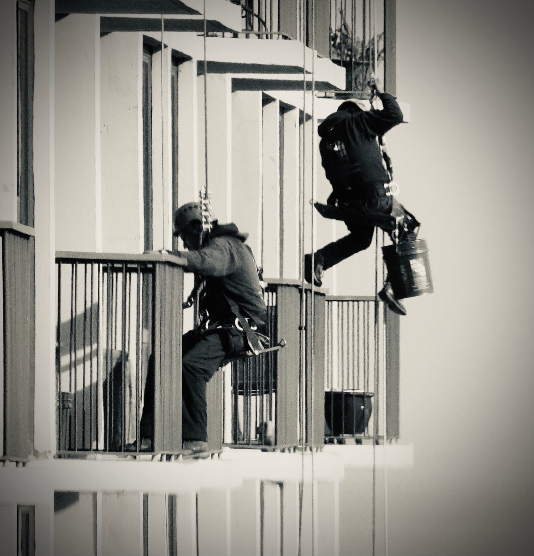 Window washers suspended beside a building