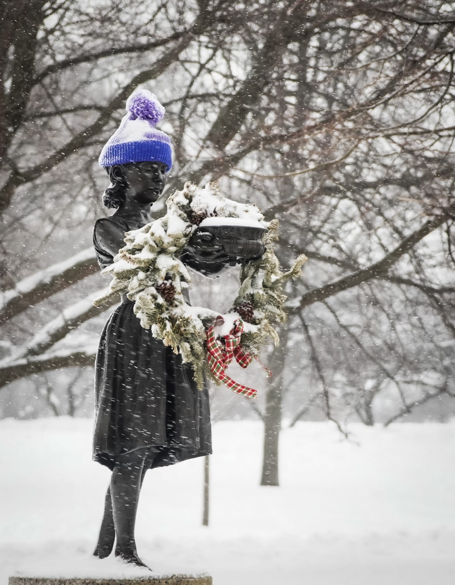 Decorated bronze girl in falling snow