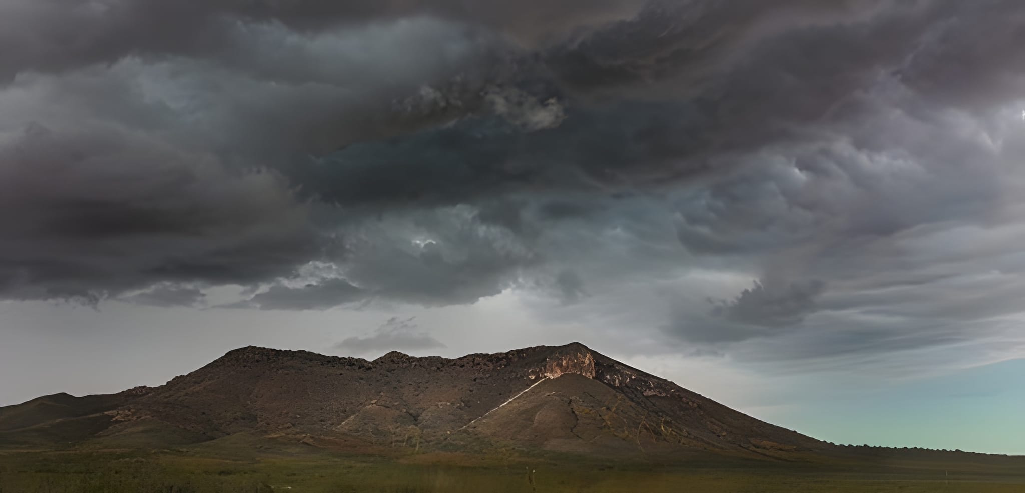 Storm clouds gathering over a desert mountain — by Ed Shpritz