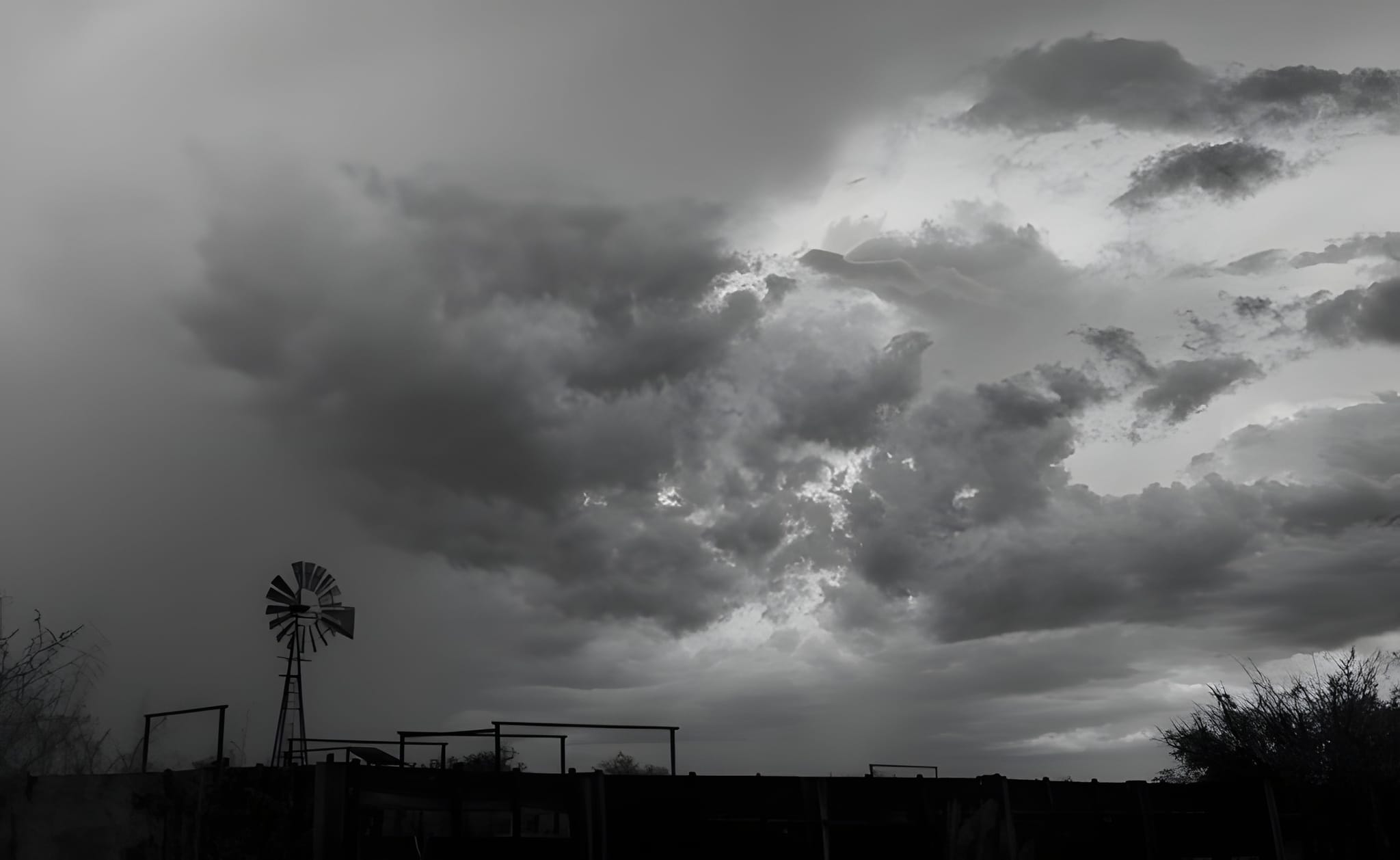 Windmill under a gathering storm, black and white — by Ed Shpritz