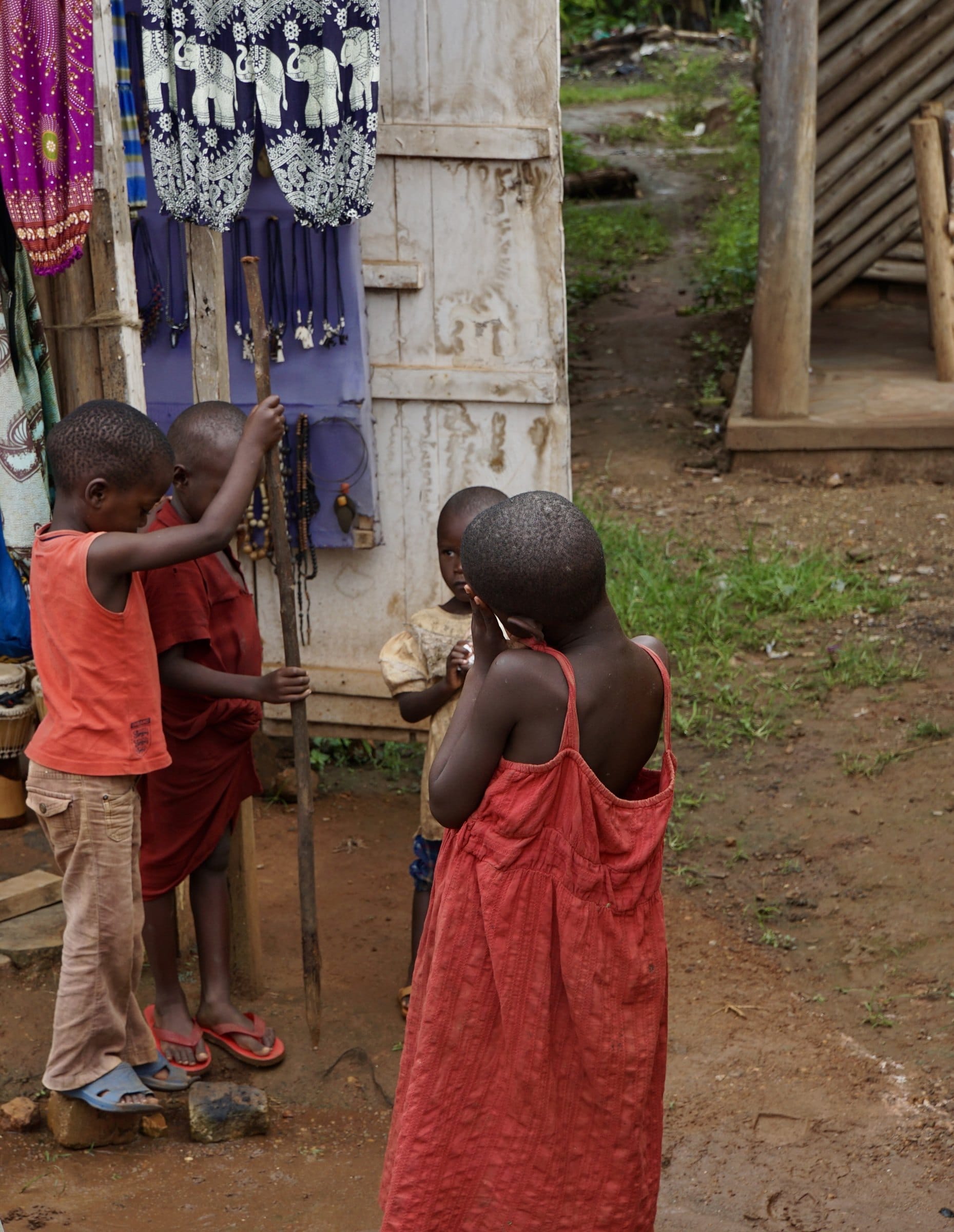 Children beside a colorful market stall. — by Ed Shpritz