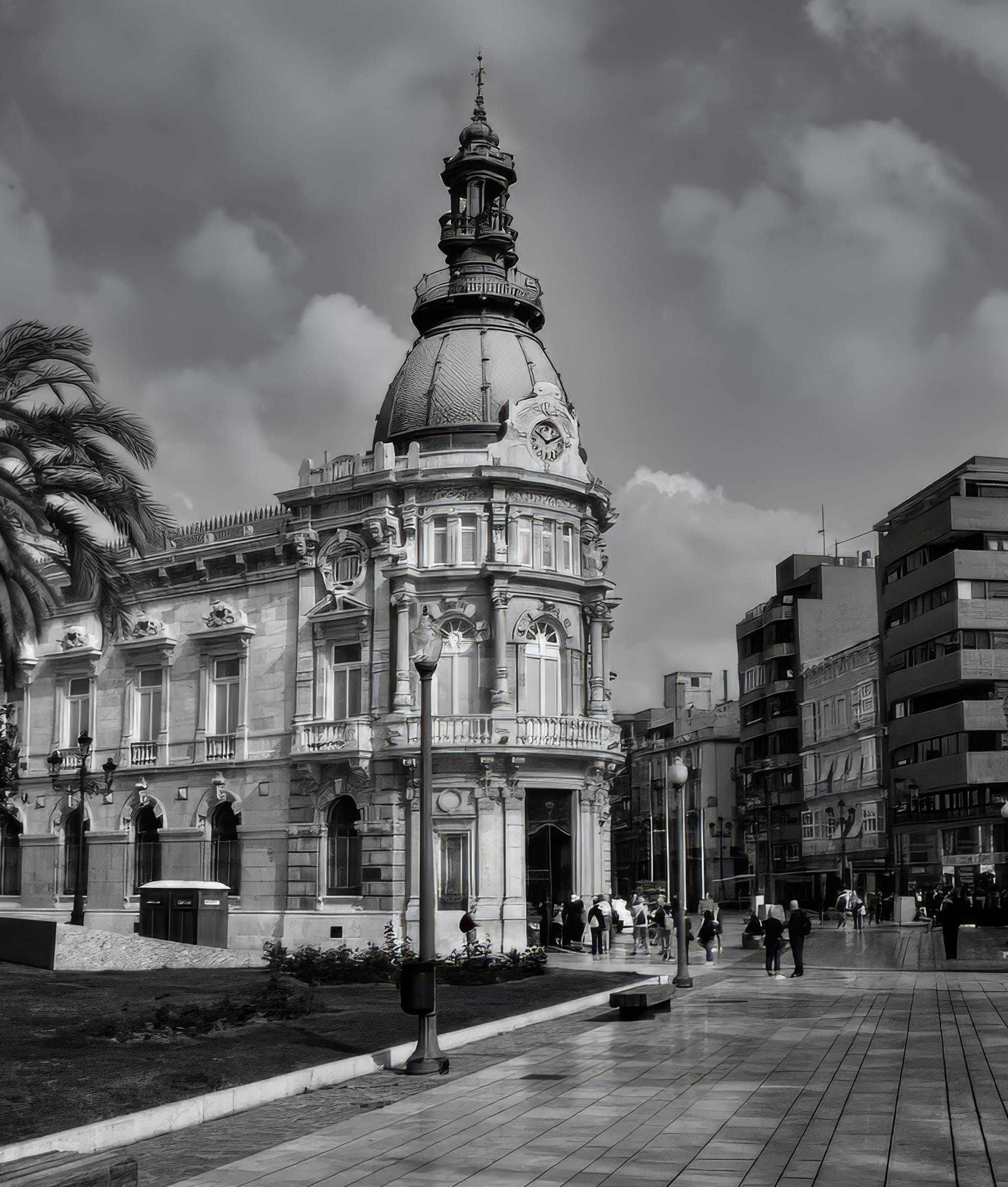 The ornate Palacio Consistorial de Cartagena beneath a dramatic sky in black and white