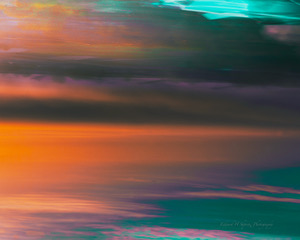 An abstract of orange, teal and green color bands from intentional camera movement