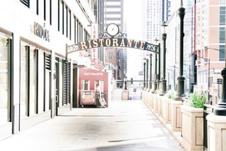An empty city side street under a Ristorante arch in soft warm pastel