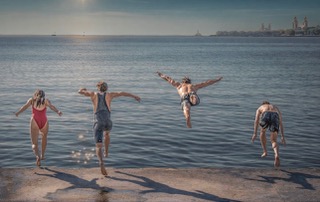 Children jumping into the lake on a summer day